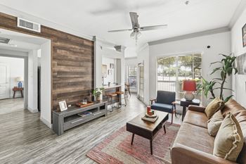 A living room with a wooden floor and a large window.